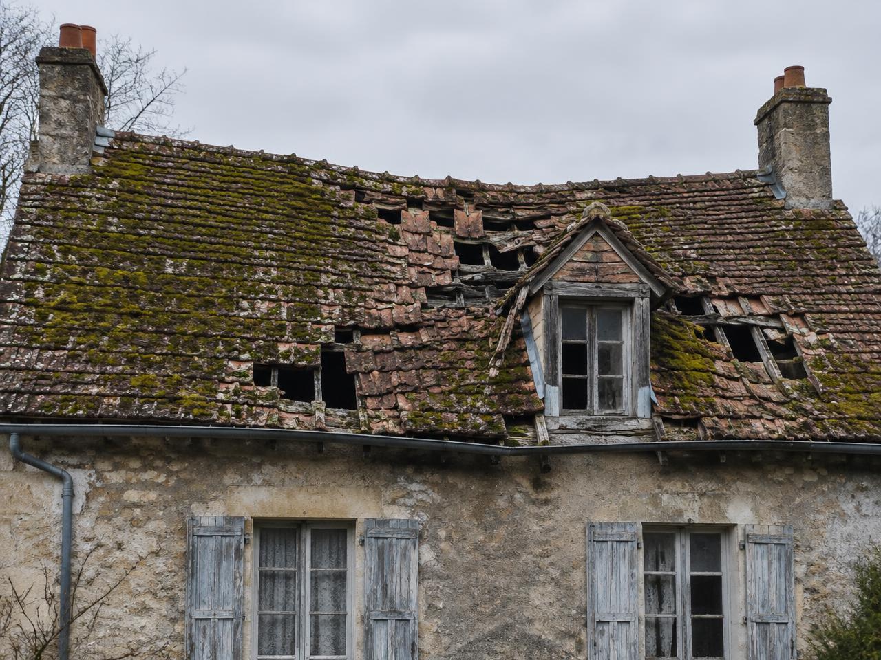Toiture ancienne dégradée, tuiles cassées et mousses avant travaux